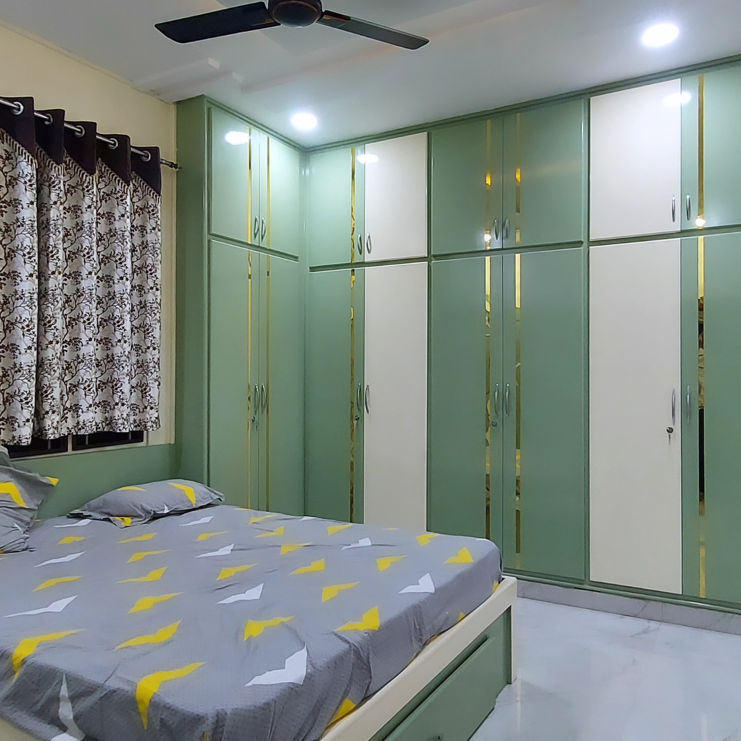 Bedroom with green and cream wardrobes